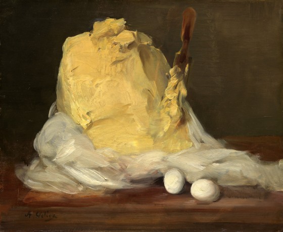 A large mound of butter with a knife in it and two eggs beside it.