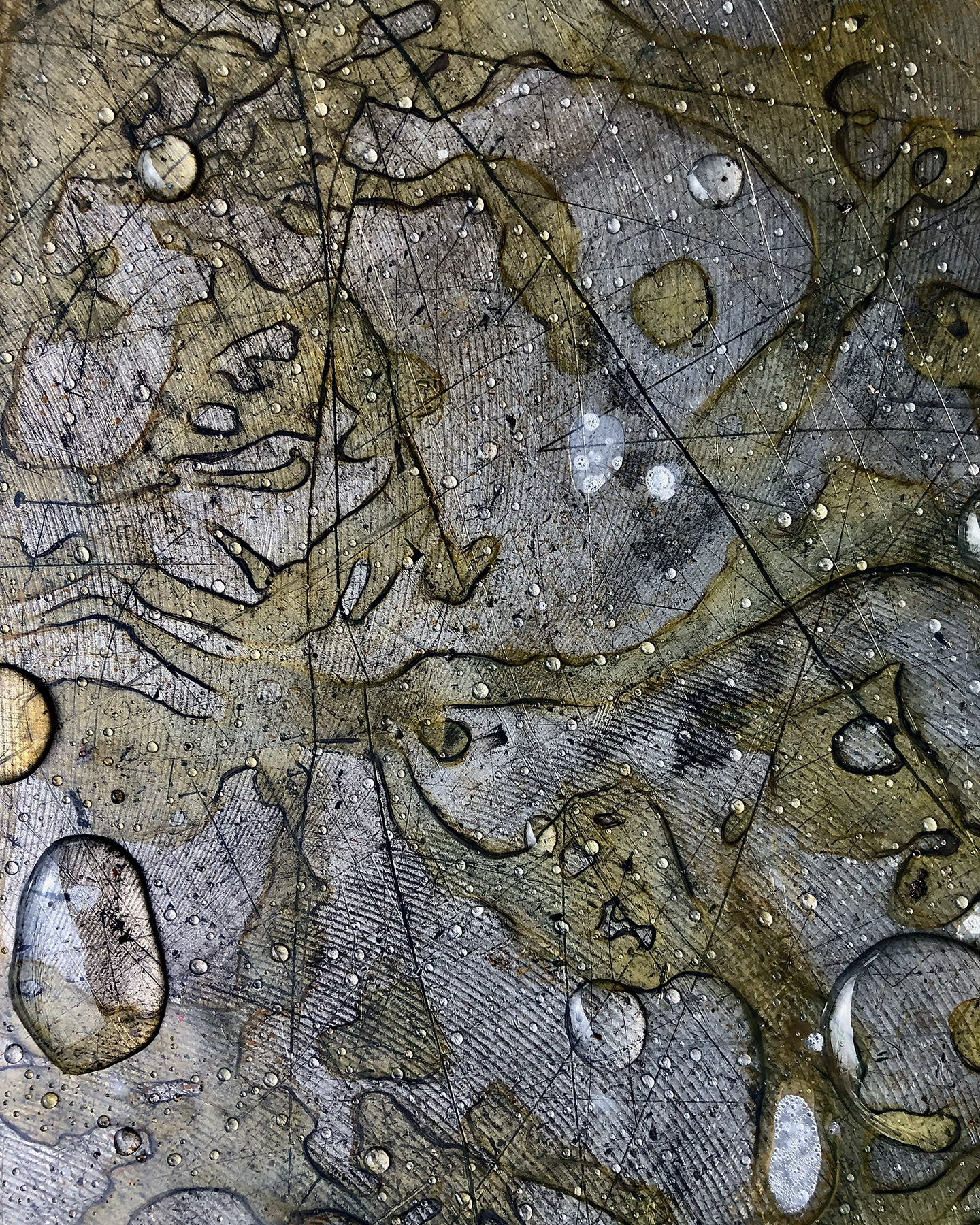 An abstract photo of rust patterns and water droplets on the machined metal surface of an industrial cutting machine stored in a parking lot.